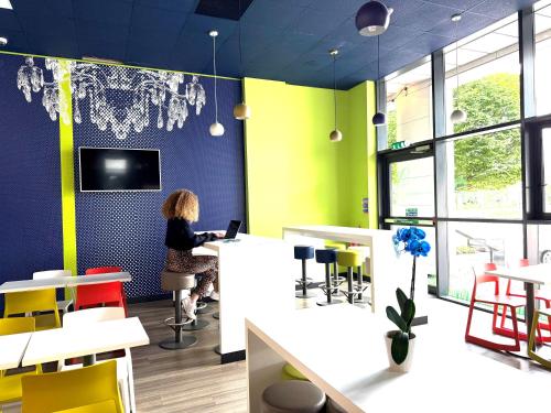 a woman standing at a counter in a restaurant at ibis budget Leeds Centre Crown Point Road in Leeds