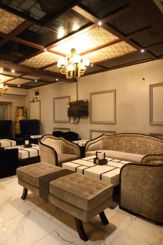 a living room with couches and tables and a chandelier at Golden Parkk Hotel in Kolkata