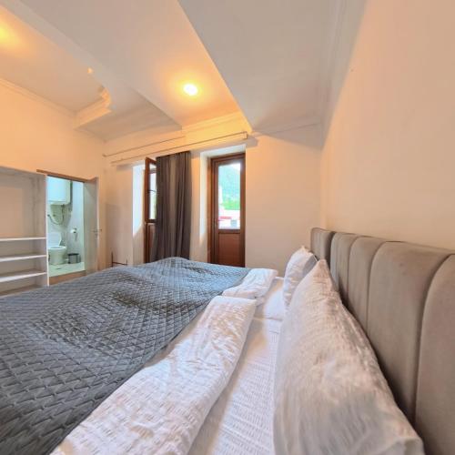 a bedroom with a large bed with pillows on it at Shara Hotel in Mestia