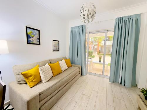 a living room with a couch with yellow pillows at Casa Mulata Coral Village Pool & Playa in Punta Cana