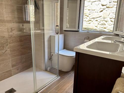 a bathroom with a shower and a toilet and a sink at Carmen Luxury House in Muros