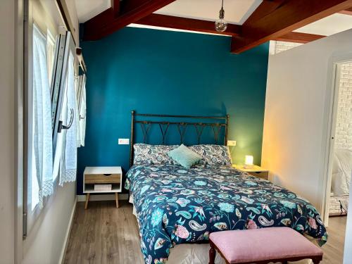 a bedroom with a bed with a blue wall at Carmen Luxury House in Muros