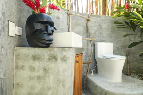 a statue of a face sitting next to a toilet at Nómada Tayrona Boutique Glamping in Santa Marta