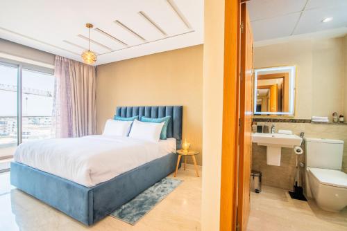 a bedroom with a king sized bed and a bathroom at New Luxury Apartment 130sqm with SeaView WiFi Unlimited with Optical Fiber in Agadir