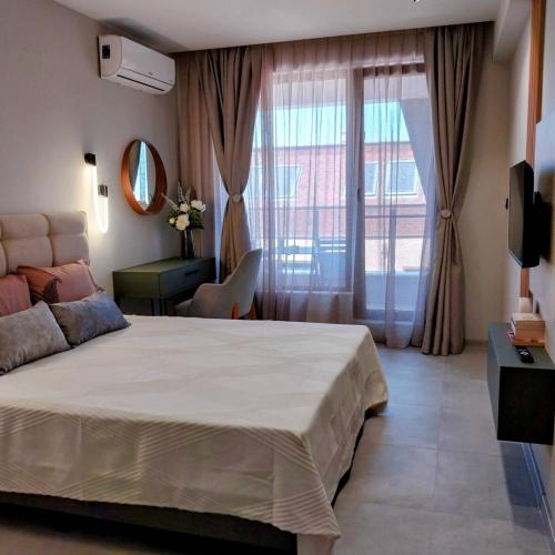 a bedroom with a bed and a large window at Ika Delux in Burgas