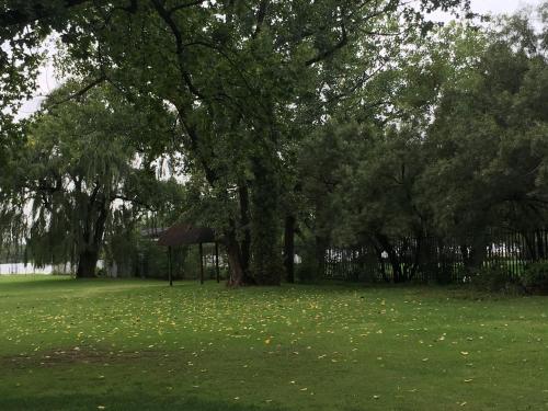 a park with trees and a gazebo in the grass at Clivia Lodge in Vanderbijlpark