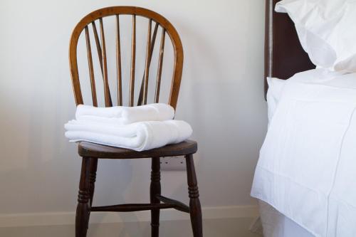 a stack of towels sitting on a chair next to a bed at Drumannon House in Portadown