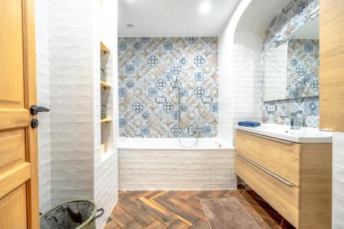 普朗德拉图尔Superbe appartement neuf, climatisé centre village的带浴缸、水槽和淋浴的浴室