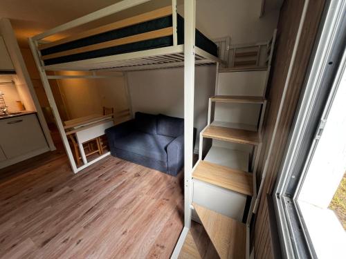 Cette petite chambre comprend des lits superposés et un canapé bleu. dans l'établissement Jolie studio à 200m de la plage principale, à Arcachon