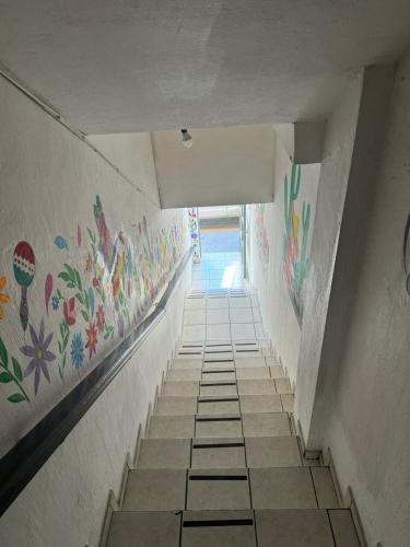 an empty hallway with colorful paintings on the walls at test hotel in Guadalajara