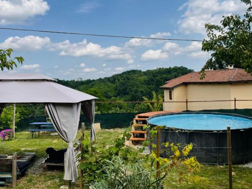 a swimming pool in a yard next to a house at Cascina Il Girasole Rosso in Cortazzone
