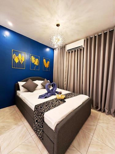 a bedroom with a bed with a blue wall at The Lounge Platinum by KRD in Butuan
