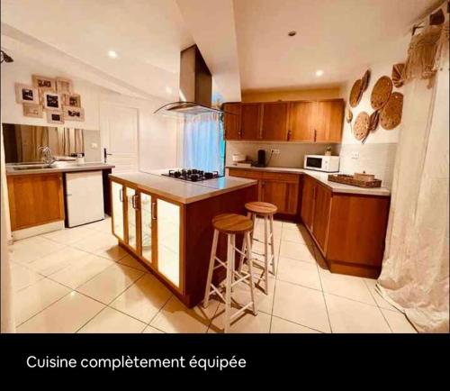 une cuisine avec des armoires en bois et un comptoir dans l'établissement Appartement détente, à Valros