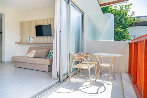 un balcone con tavolo, sedie e divano di Flat Ile de Pipa Sicilia by Qavi a Pipa