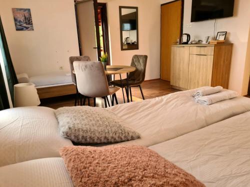 a bedroom with a bed and a table and chairs at Whispering Pines in Šišava