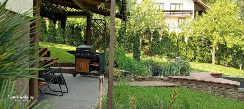 a patio with a grill in a garden at Apartament Kapi in Kalwaria Zebrzydowska