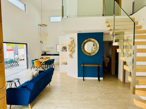 un salon avec un canapé bleu et un mur bleu dans l'établissement Maison LUMIERE, à Saleilles