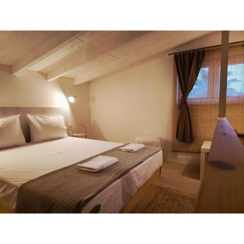a bedroom with a bed with two towels on it at Alos 2 in Ammouliani
