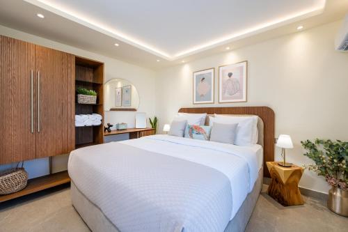 a bedroom with a large white bed and a cabinet at Diamante Del Mar Thalia and Erato in Kos