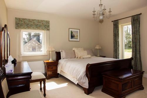 1 dormitorio con cama, escritorio y ventana en Ballinclea House Bed and Breakfast en Brittas Bay