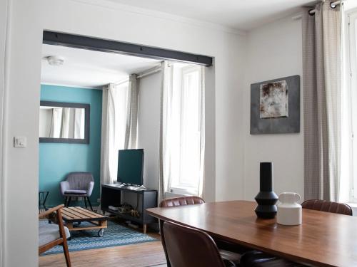 un salon avec une table et une télévision dans l'établissement Terrace apartment - near city center - 4 bedrooms, à Reims