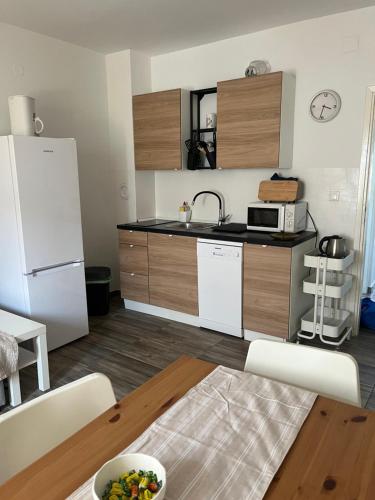 kuchnia z białą lodówką i stołem w obiekcie Levant, cosy and modern apartment in Novalja center w Novalji