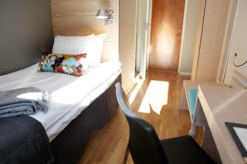 a small bedroom with a bed and a desk at Hotell Aston in Karlskrona