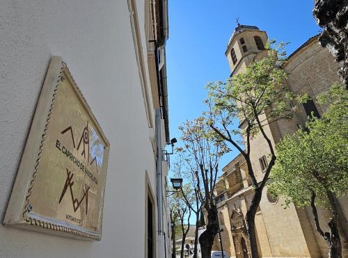 a sign on the side of a building with a clock tower at El Capricho de Vandelvira in Úbeda