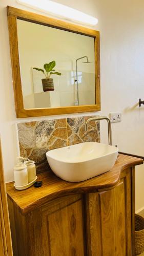 a bathroom with a white sink and a mirror at Tulusia Lake View in Arusha