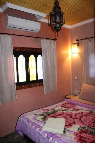 a bedroom with a bed with flowers on it at Dar Diafa Kaltom in Ouzoud