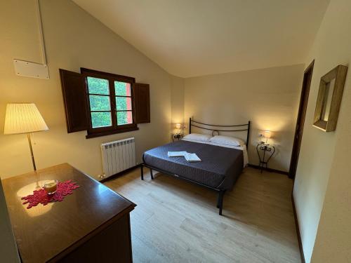 a bedroom with a bed and a desk and a table at Agriturismo Capo Dezza in Coreglia Antelminelli