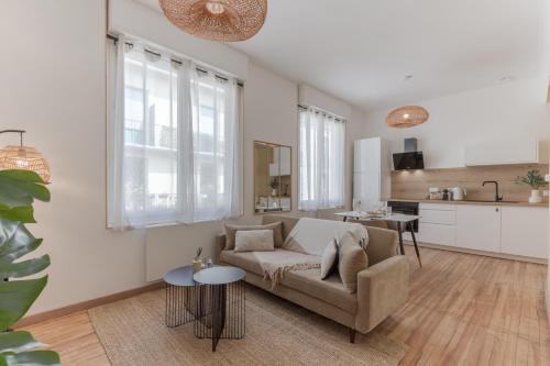 un salon avec un canapé et une cuisine dans l'établissement Le Cazaubon - T2 lumineux et confortable, à Pau