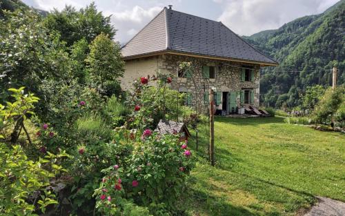 a stone house with a garden and flowers at Chez Maria in Corbel