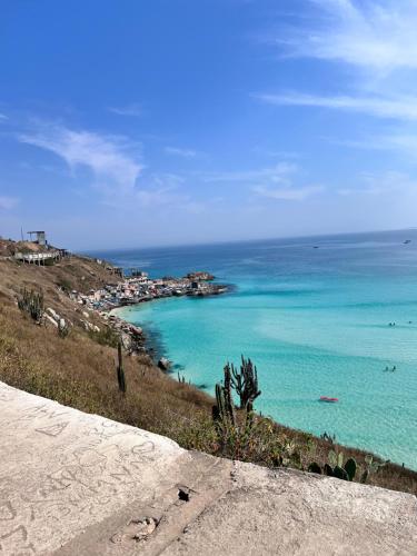a view of the ocean from the top of a hill at Loft Prainha 101, arraial do cabo in Arraial do Cabo