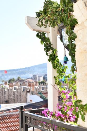 a bench sitting on a balcony with flowers at Villa Ephesus Hotel in Kusadası