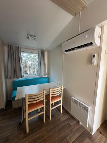 une salle à manger avec une table et deux chaises dans l'établissement Mobil Home 2 chambres Sous les pins, à Torreilles