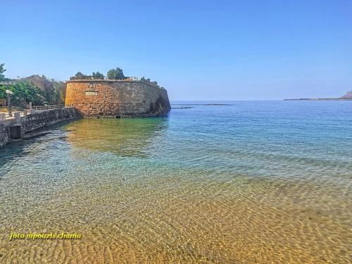 a large body of water next to a brick wall at Hippie City Hostel in Chania Town