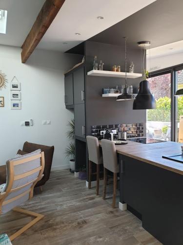 a kitchen with black cabinets and a counter with chairs at L'Atelier in Auxerre