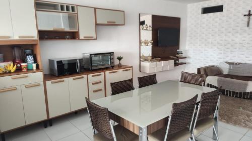 eine Küche mit Tisch und Stühlen und einer Couch in der Unterkunft Alugo por temporada! in Campina Grande