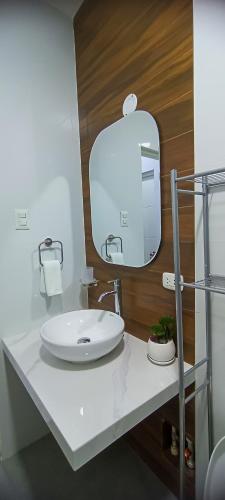 a bathroom with a white sink and a mirror at El Principe Hoteles in Piura