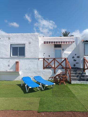 una casa con dos sillas azules en el césped en Vivaldi Summer, en Icod de los Vinos