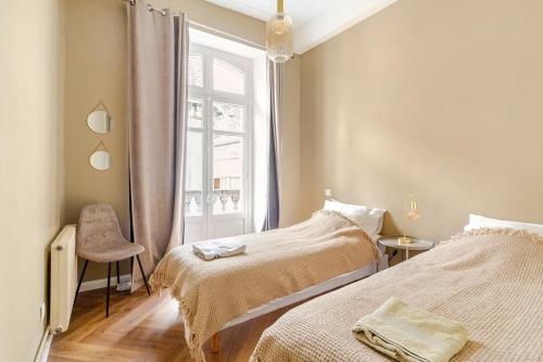 une chambre avec deux lits et une fenêtre dans l'établissement Magnifique appartement rénové, à Bagnères-de-Bigorre