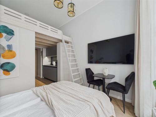 Un dormitorio con una litera y una mesa y sillas. en Chic and Compact Loft in Old Riga, en Riga