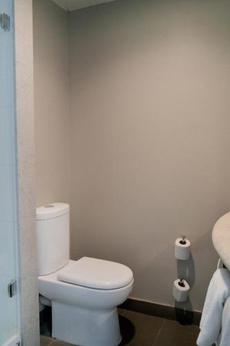 a bathroom with a toilet and two rolls of toilet paper at ibis Copiapo in Copiapó