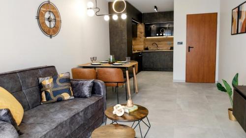 una sala de estar con un sofá y una mesa en Ika Apartment Central, en Burgas