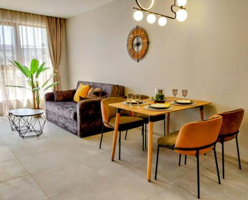 Una sala de estar con una mesa y sillas y un sofá. en Ika Apartment Central, en Burgas