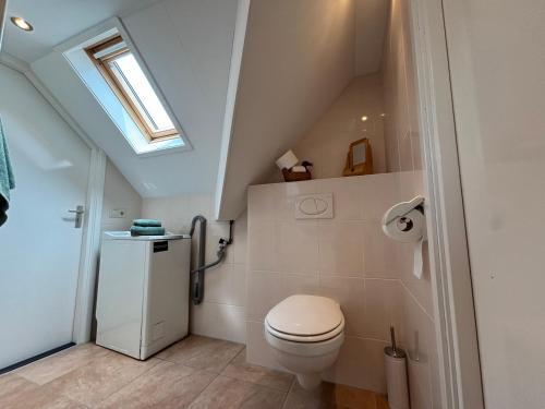 a bathroom with a toilet and a skylight at 't Veldhuisje in Kootwijkerbroek