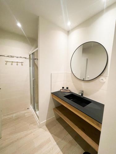 une salle de bain avec un lavabo et un miroir dans l'établissement Pipa, à Narbonne