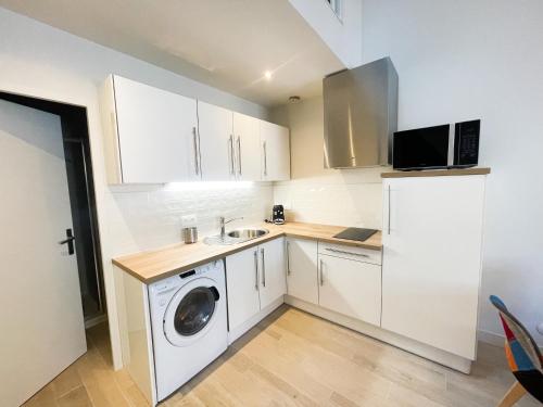 une cuisine avec un lave-linge et un réfrigérateur dans l'établissement Pipa, à Narbonne