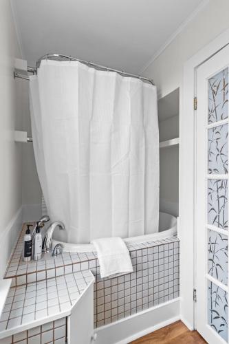 a bathroom with a tub and a shower curtain at Stay on Bond 2BR Queen Deck Vws in St. John's
